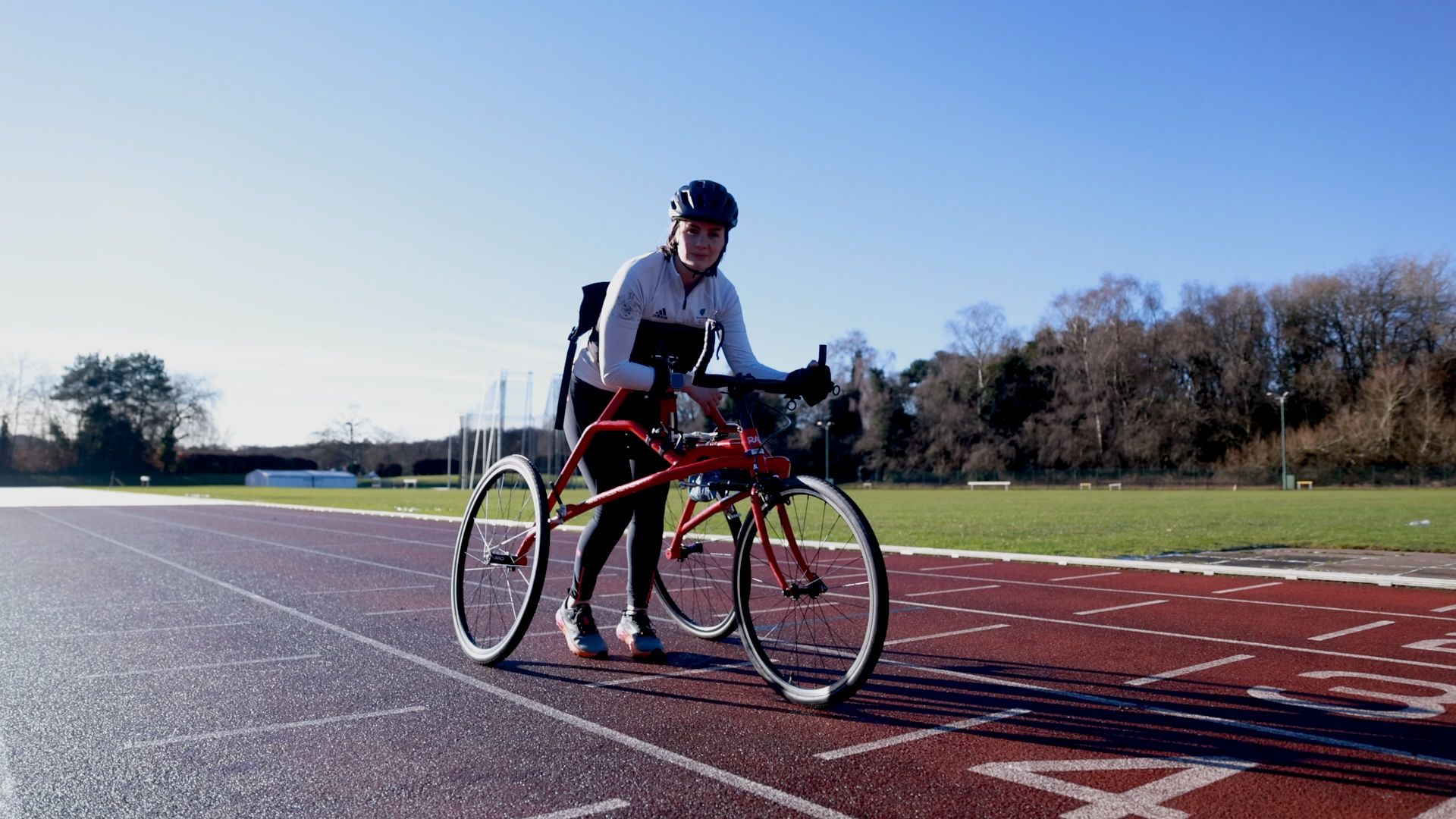 Tully Kearney poses for a picture with her frame runner, on a running track in Loughborough where she operates her running club for young children with disabilities,