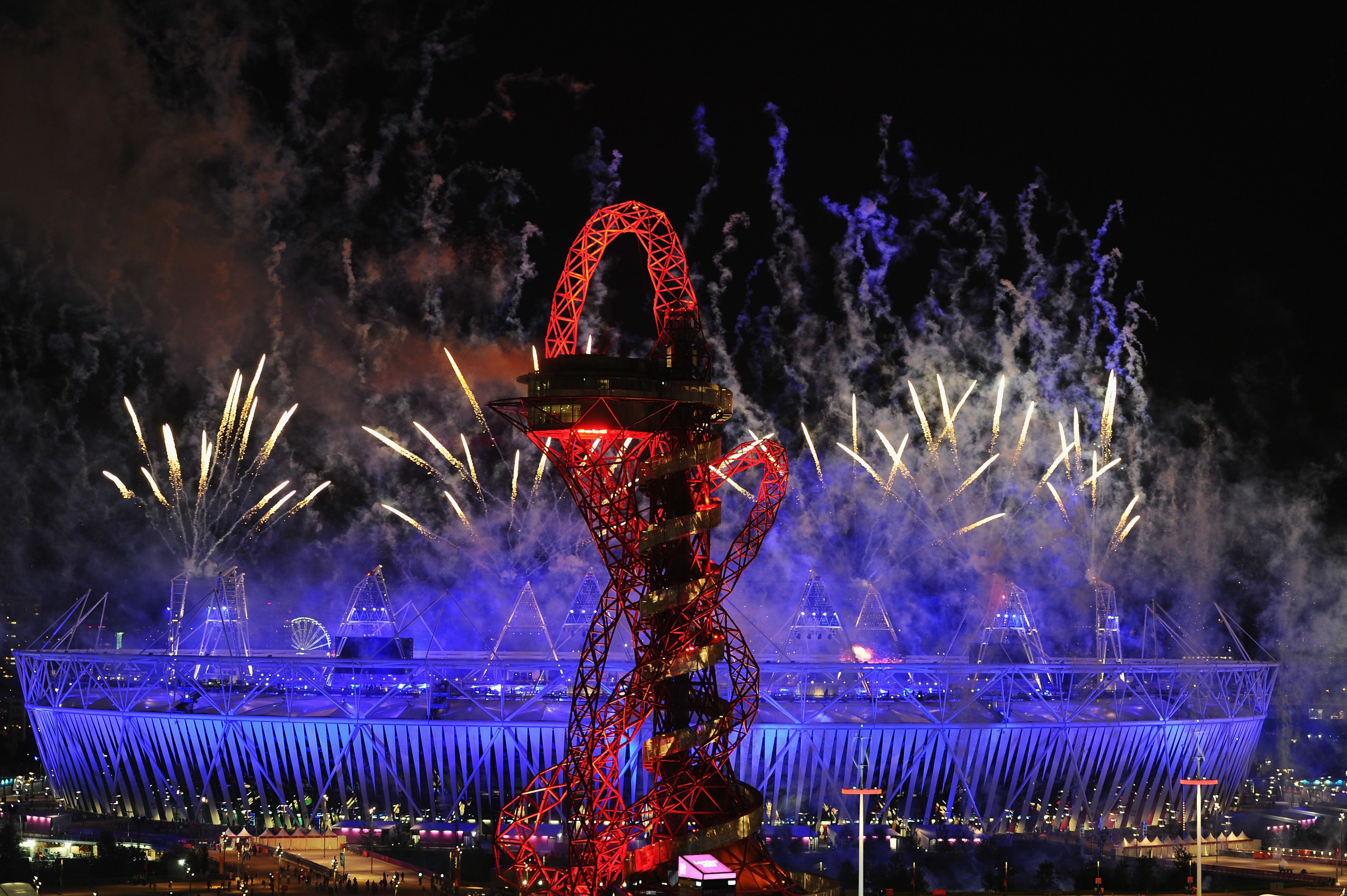 London 2012 Olympic Opening ceremony, fireworks explode over London stadium with the Oribtal feature in the foreground.